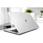 Modern HP laptop with sleek design on a white desk in a bright room.