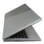 Silver laptop with partially open lid showing keyboard and ports.